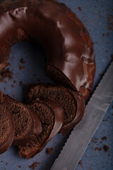 Dark chocolate cake covered with icing covered on a dark background. Selective focus.
