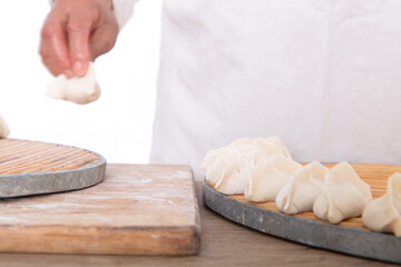 The Chinese chef in the kitchen is making dumplings
