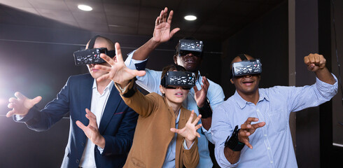 Multinational group of colleagues using VR glasses during team building seminar
