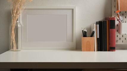 Workspace with mock up frame, stationery, books and copy space in home office