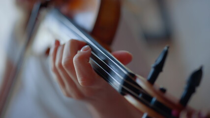 Teenage girl hand playing violin. Woman fingers pressing strings on violin