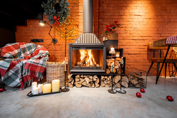 Fireplace area of a beautiful loft-style interior with real brick and concrete floors decorated for the New Year holidays. The concept of home comfort