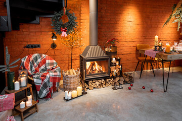 Fireplace area of a beautiful loft-style interior with real brick and concrete floors decorated for the New Year holidays. The concept of home comfort