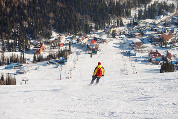 Athlete is snowboarding on the snowy slopes.