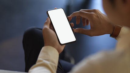 Businessman hands holding smartphone while relaxed sitting in office room