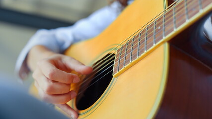 Teenage girl hand playing guitar. Female musician learning to play guitar