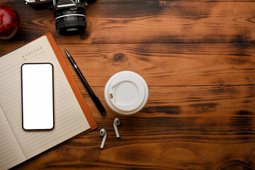 Top view of vintage workspace with blank screen smartphone with office supplies 