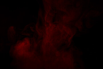 Fototapeta premium Colorful smoke close-up on a black background. Red cloud of smoke.