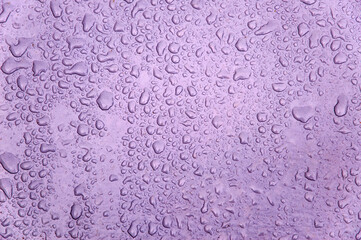 small and large drops of condensation on frosted colored glass