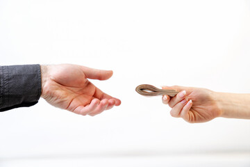 Bribery. A man's hand in a black shirt takes a bribe from a woman's hand. Side view. White background. The concept of the world anti-corruption day, 9 December
