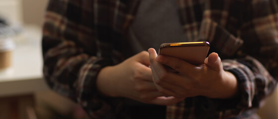 Female in Scott shirt hand texting on smartphone
