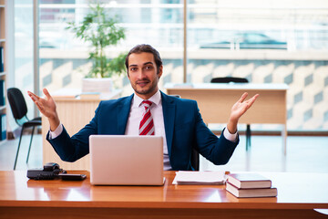 Young handsome employee working in the office