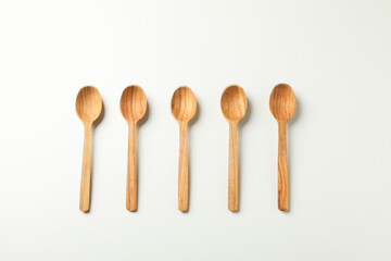 Empty wooden spoons on white background, top view
