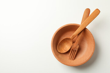 Wooden bowl with fork and spoon on white background