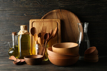 Different wooden kitchenware on wooden table, space for text