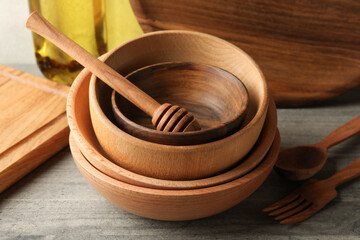 Different wooden kitchenware on gray table, close up