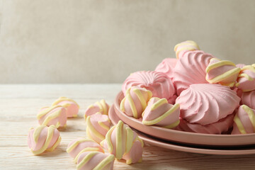 Plate with sweet marshmallow on wooden background