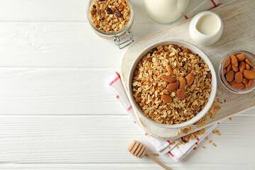 Concept of tasty breakfast with granola on white wooden background