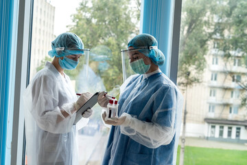 two young interns work with test tubes with blood for laboratory research to detect virus