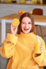 Beautiful young woman drinking orange juice at home