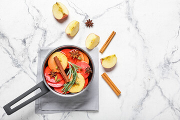 Saucepan with hot mulled wine on white background