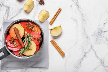 Saucepan with hot mulled wine on white background