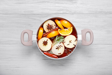 Saucepan with hot mulled wine on table