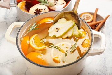 Saucepan with hot mulled wine on table