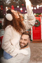 Happy young couple celebrating Christmas outdoors