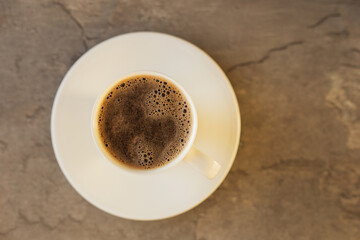 A cup of black coffee on dark stone table. Top view.