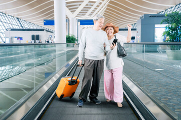 Happy senior couple using a smartphone in airport