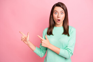 Photo of cute shocked girl indicate forefinger empty space wear teal pullover isolated pink color background