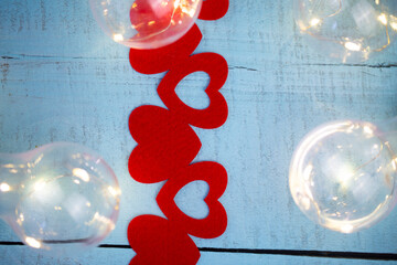 wooden turquoise background with decorative ribbon of red hearts