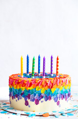 Handmade colorful big birthday cake with multicolored candles.