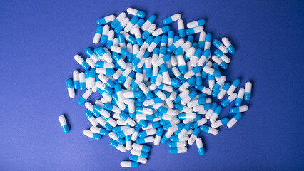 White and blue pills on a blue background. medical background
