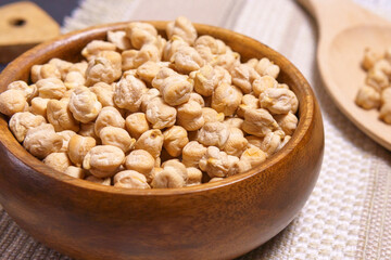 Bowl with organic dry chickpeas on an stone table, selective focus.