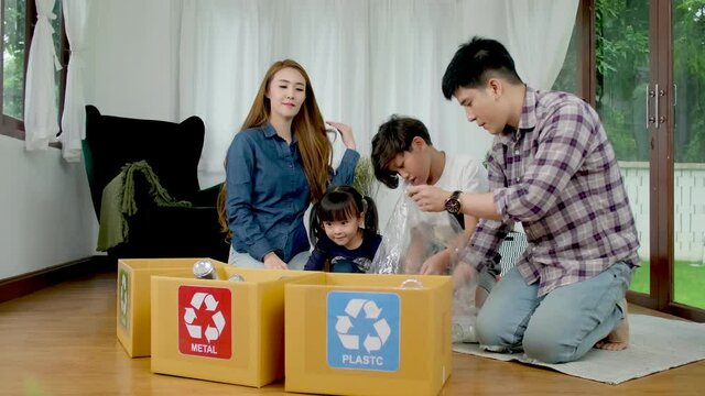 Asian Family recycle concept. Families are helping to separate recyclable waste in house.Father or mother teaching her daughter  or sonhow to separate solid waste.
