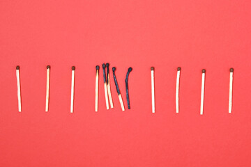 burnt and new matches on a red background
