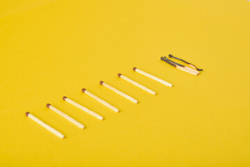 burnt and new matches on a yellow background
