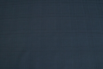Background made of natural dark gray fabric in a cage for the autumn-winter wardrobe. Horizontal orientation