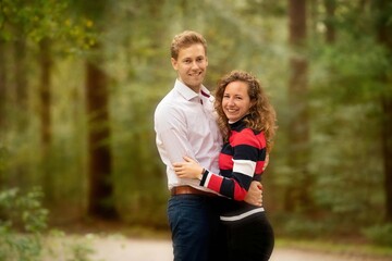 Fototapeta premium Autumn outdoor portrait of young pair. Boy and girl in the forest. vintage colors