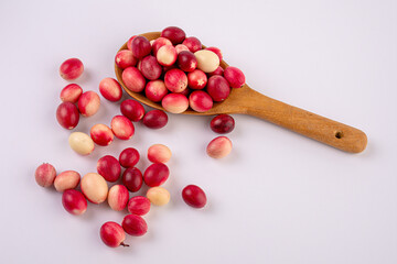 Carissa carandas and wooden spoon isolated on white background.