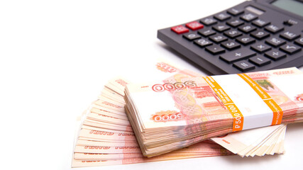 Banknotes, Russian banknotes, spread out on a white background with a calculator, isolated, panoramic banner format, close-up, space for text