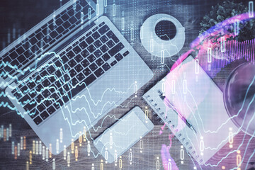 Financial market graph and top view computer on the desktop background. Double exposure. Investment concept.