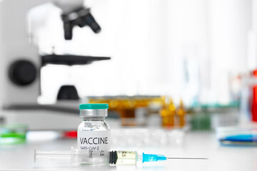 Vaccine in vial for injection on table against background of laboratory