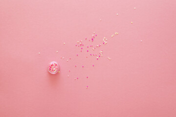 Purple and gold decorative hearts scattered on pink background, flat lay, top view, copy space.