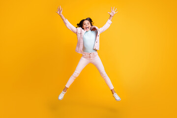 Fototapeta na wymiar Full size photo of crazy cheerful young little girl jump air star shape raise hands isolated on yellow color background
