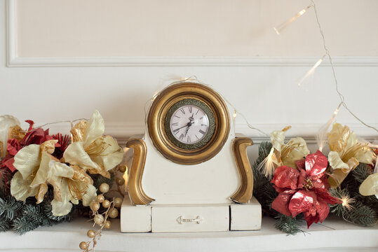 antique clock on the fireplace with New Year decoration
