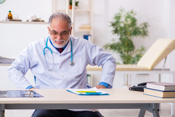 Old male doctor tired after night shift