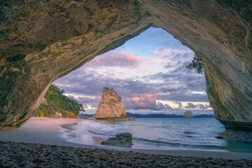 view from the cave at cathedral cove beach at sunrise,coromandel,new zealand